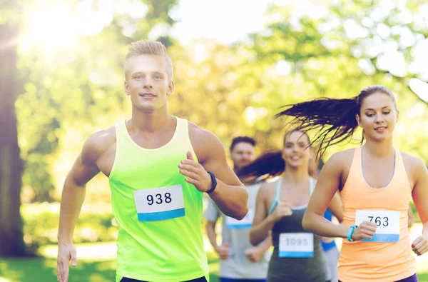 Happ junge Sportler rasen mit Abzeichen-Nummern — Stockfoto