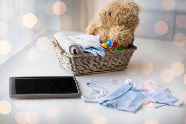 Close up de roupas de bebê, brinquedos e tablet pc — Fotografia de Stock