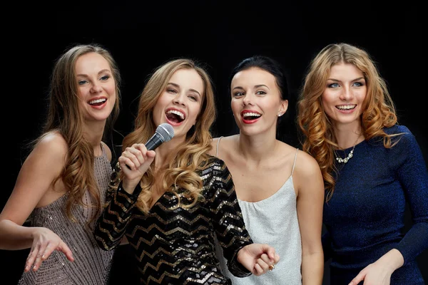 Mulheres jovens com microfone cantando karaoke — Fotografia de Stock