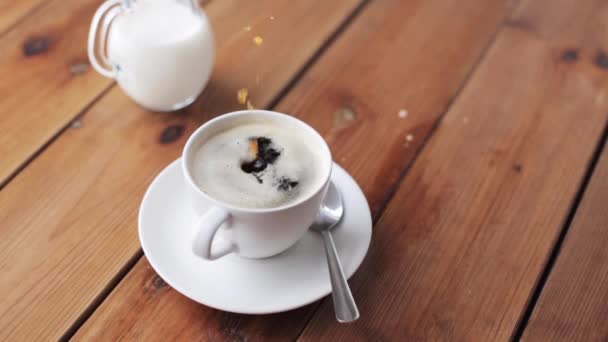 Hand släppa socker i kaffekopp — Stockvideo