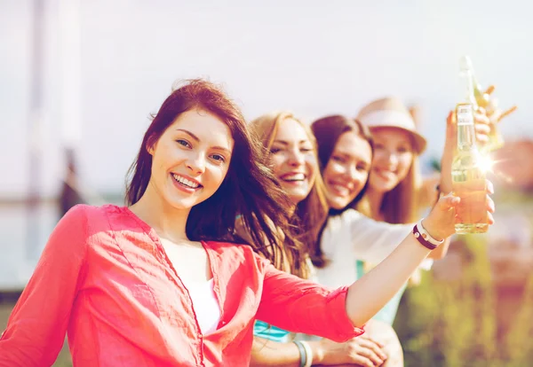 Girls with drinks on beach — Stock Photo, Image