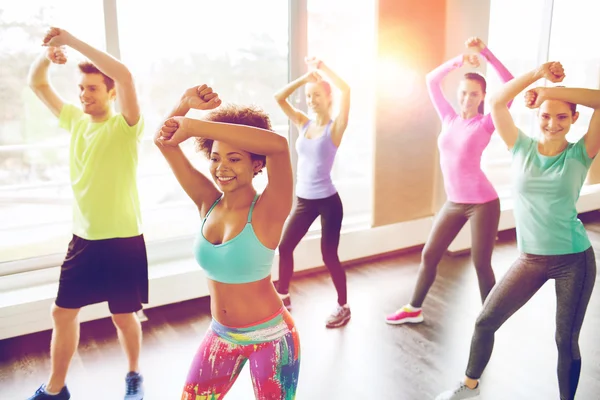Grupa uśmiechniętych ludzi tańczy w siłowni — Zdjęcie stockowe
