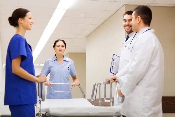 Группа счастливых врачей с каталкой в больнице — стоковое фото