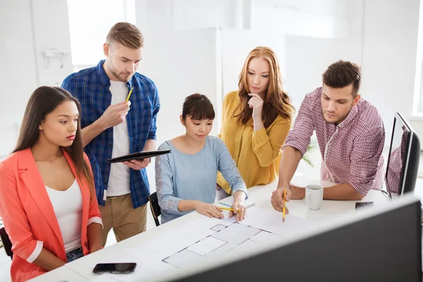 Kreativa team med blueprint arbetar på kontor — Stockfoto