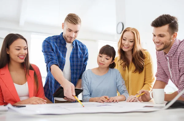 Creative team with blueprint working at office — Stock Photo, Image