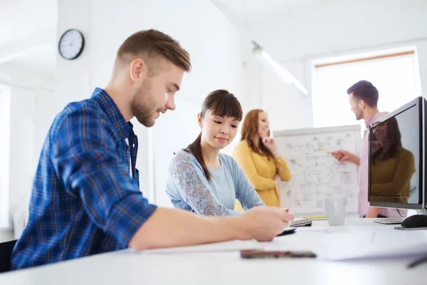 Creative team with blueprint at office — Stock Photo, Image