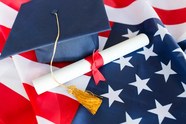 Chapéu de solteiro e diploma na bandeira americana — Fotografia de Stock