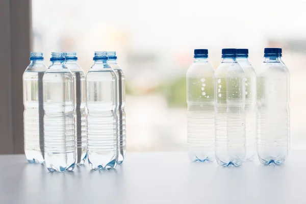 Flaschen mit Trinkwasser auf dem Tisch — Stockfoto