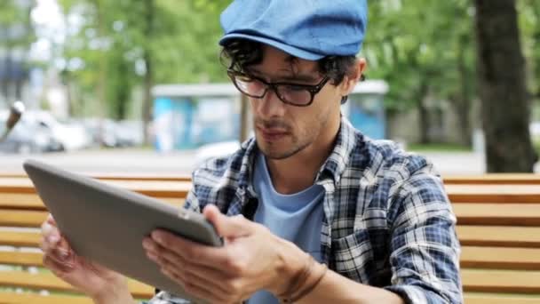 Mann mit Tablet-PC sitzt auf Bank — Stockvideo