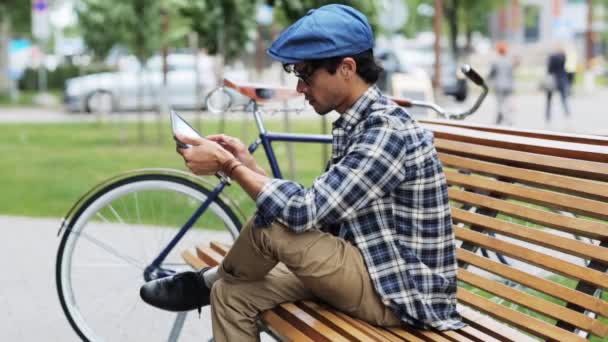 Людина з планшетним ПК сидить на лавці — стокове відео