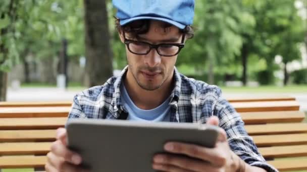 Hombre con la tableta PC sentado en el banco — Vídeos de Stock