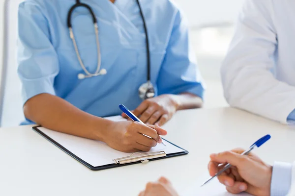 Groupe de médecins avec presse-papiers écriture — Photo