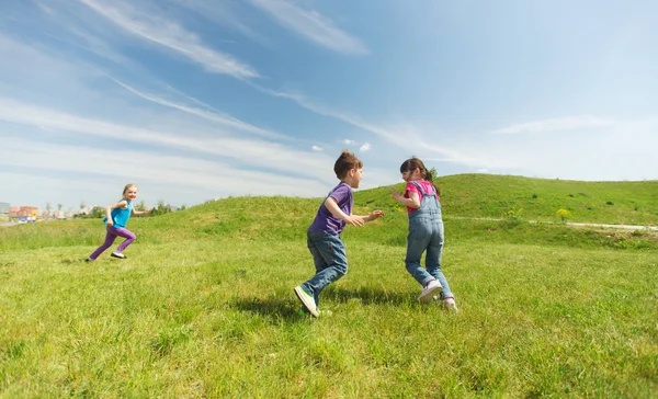 Grupa szczęśliwy dzieci biegają na zewnątrz — Zdjęcie stockowe