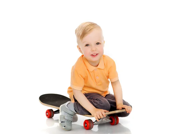 스케이트 보드에 앉아 행복 한 소년 — 스톡 사진