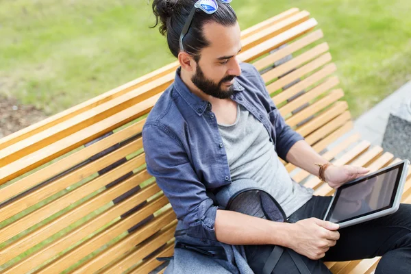 Uomo con tablet pc seduto su panca — Foto Stock
