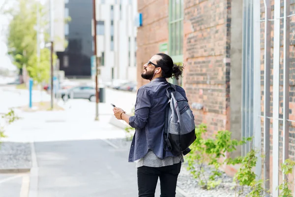 Férfi fülhallgató és smartphone séta a városban — Stock Fotó