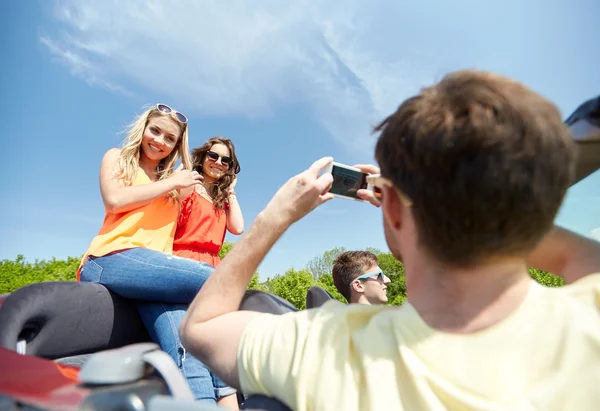 Amigos dirigindo no carro e fotografando — Fotografia de Stock