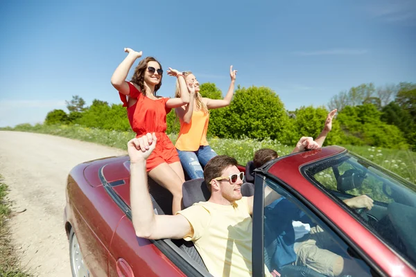 Amigos felizes dirigindo em carro cabriolet — Fotografia de Stock