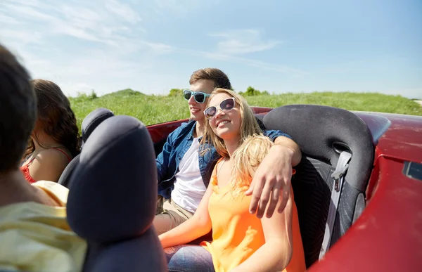 Amigos felizes dirigindo em carro cabriolet — Fotografia de Stock