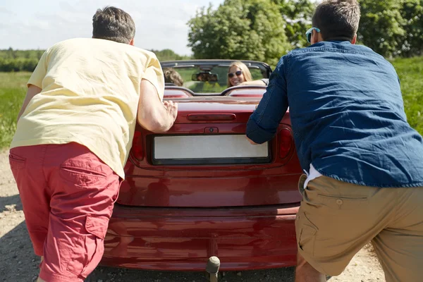 Amigos empurrando carro cabriolet quebrado — Fotografia de Stock