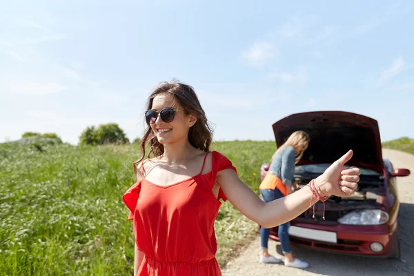 Women with broken car hitchhiking — Zdjęcie stockowe