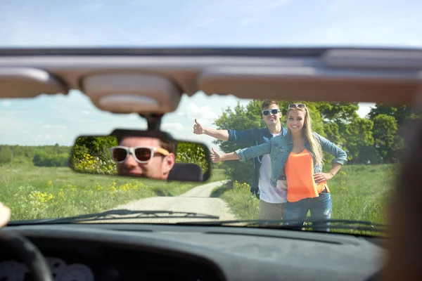 Casal carona e parar de carro no campo — Fotografia de Stock