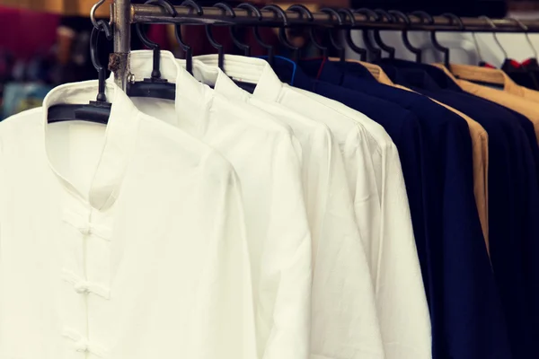 Hombres camisas en perchas en asiático mercado — Foto de Stock