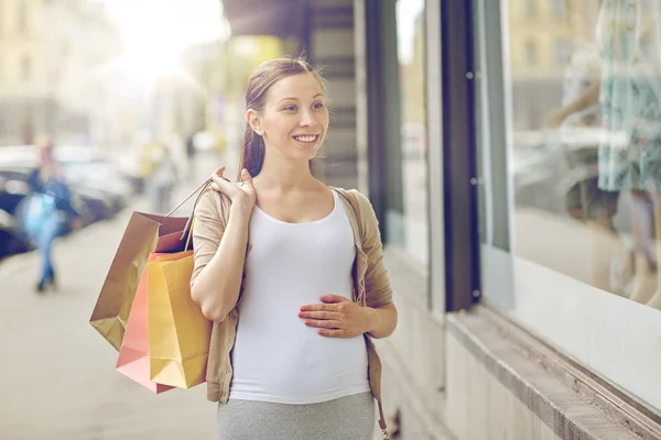 Mulher grávida feliz com sacos de compras — Fotografia de Stock