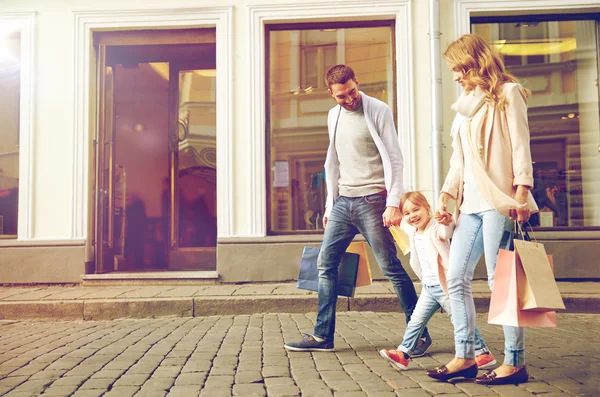 Gelukkig gezin met kind en boodschappentassen — Stockfoto