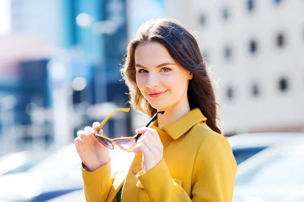 Lachende jonge vrouw met een zonnebril in de stad — Stockfoto