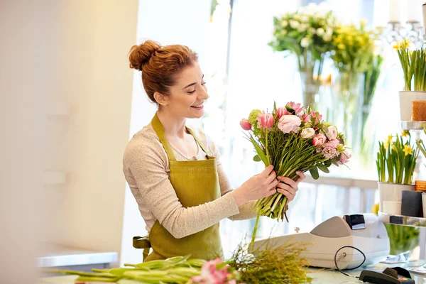 Sorridente florista mulher fazendo bando Imagens De Bancos De Imagens