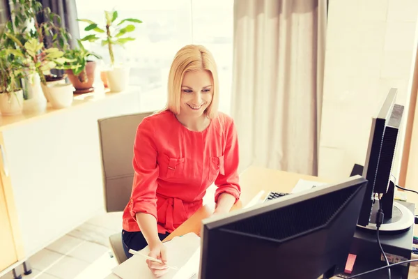 Happy creative female office worker with computers — Stock Photo, Image