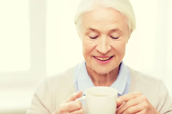 Mulher sênior feliz com xícara de chá ou café — Fotografia de Stock