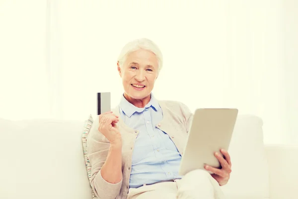 Senior vrouw met tablet pc en creditcard — Stockfoto