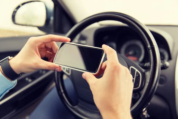 Gros plan de la main de l'homme avec smartphone voiture de conduite — Photo