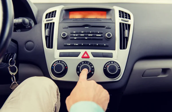 Primer plano de la mano masculina utilizando el control climático en el coche — Foto de Stock