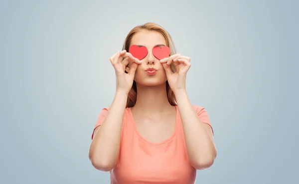 Glückliche junge Frau mit roten Herzformen auf den Augen — Stockfoto