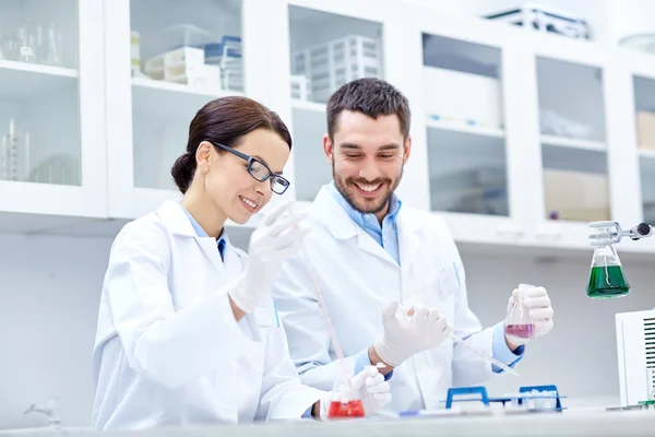 Jóvenes científicos haciendo pruebas en laboratorio — Foto de Stock