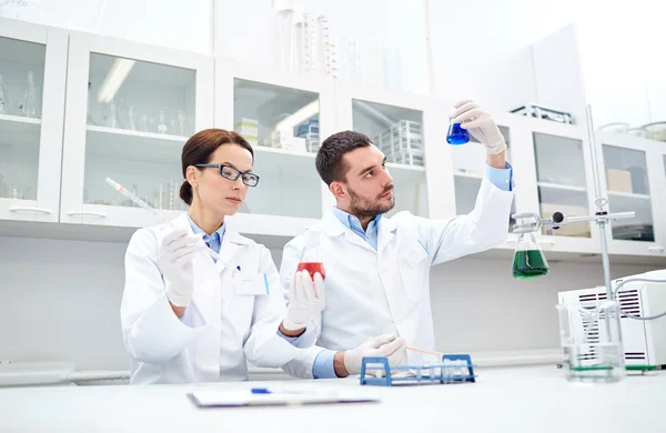 Jóvenes científicos haciendo pruebas en laboratorio — Foto de Stock