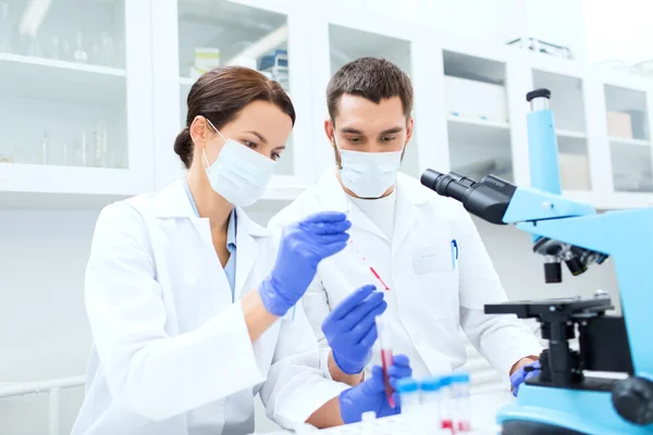 Jóvenes científicos haciendo pruebas en laboratorio — Foto de Stock