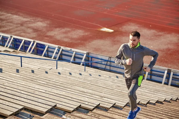 Young man running upstairs on stadium — Stock Photo, Image
