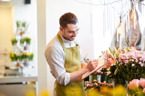 Florista homem com área de transferência na loja de flores — Fotografia de Stock