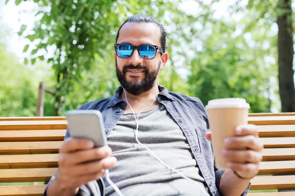 Mann mit Kopfhörer und Smartphone trinkt Kaffee — Stockfoto