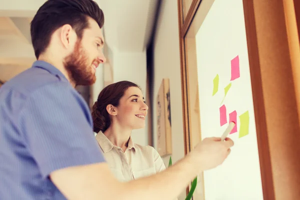 Kreativa team med klistermärken på glas på kontor — Stockfoto