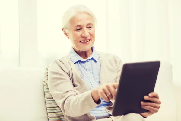 Mulher sênior feliz com tablet pc em casa — Fotografia de Stock