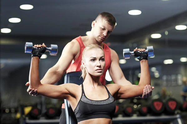 Hombre y mujer con mancuernas en el gimnasio — Foto de Stock