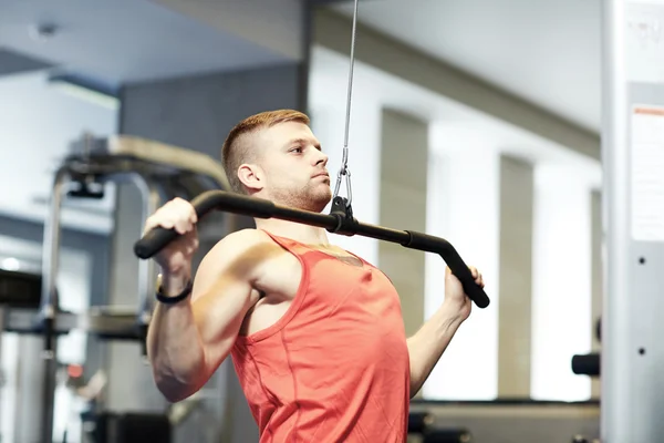 Man flexing muscles on cable machine gym — Stock Photo, Image