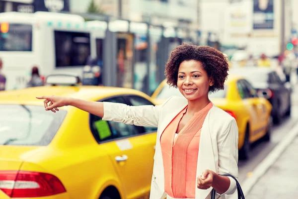 Glückliche Afrikanerin erwischt Taxi — Stockfoto