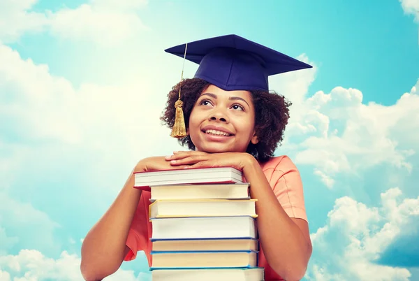 Happy african bachelor girl with books over sky — Stock Photo, Image