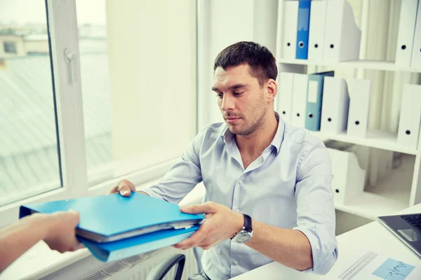 Businessman taking folder from secretary in office — Stock Photo, Image